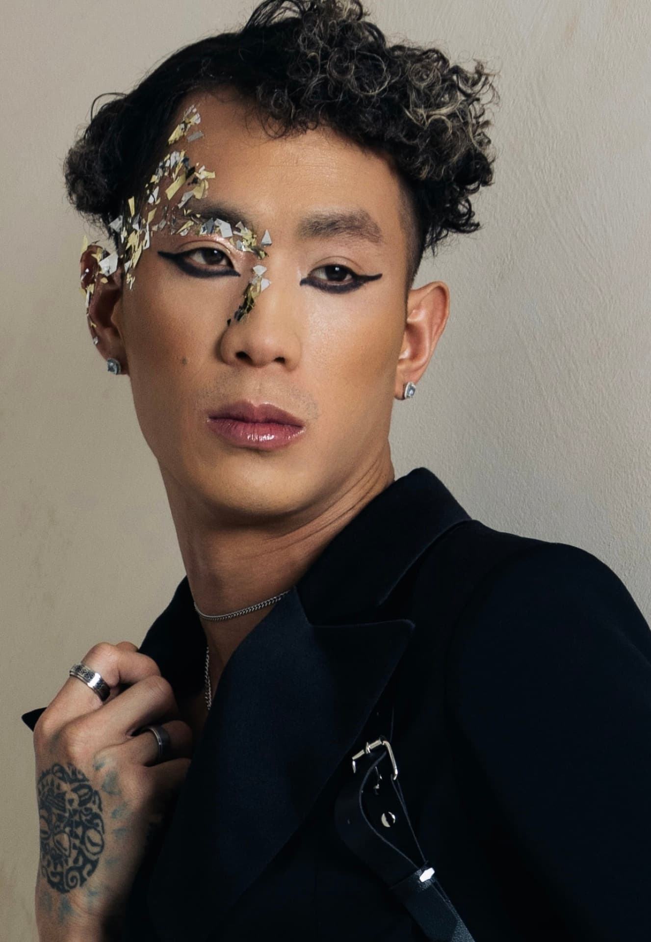Creative editorial makeup with gold leaf accents and dramatic winged liner