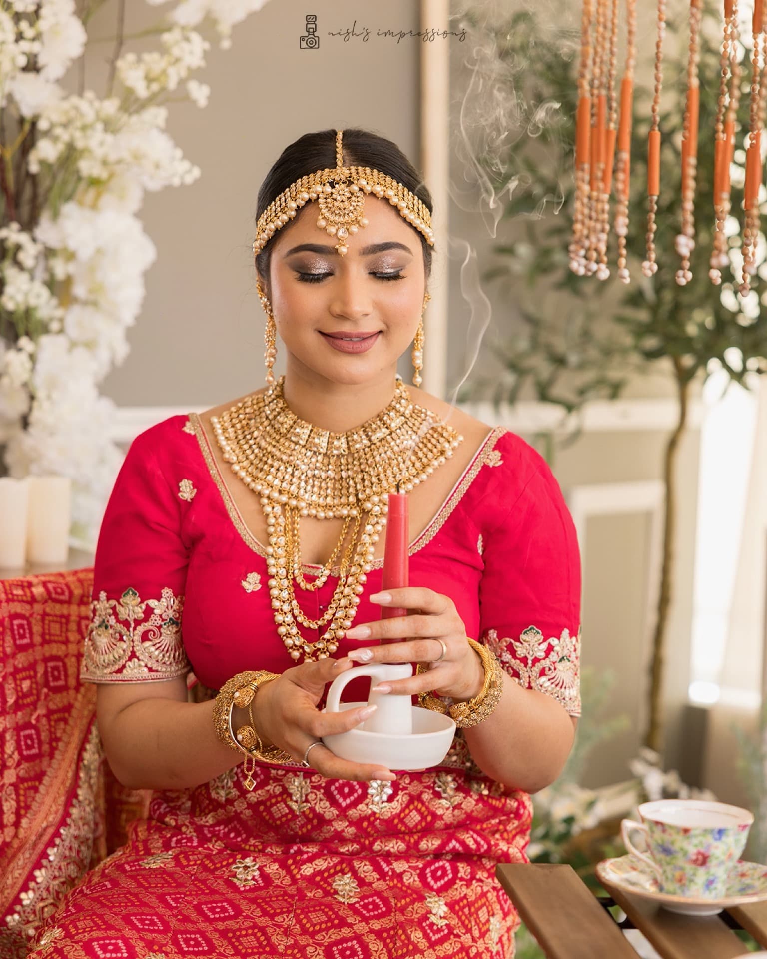 Indian bride in traditional red lehenga with layered gold bridal jewelry